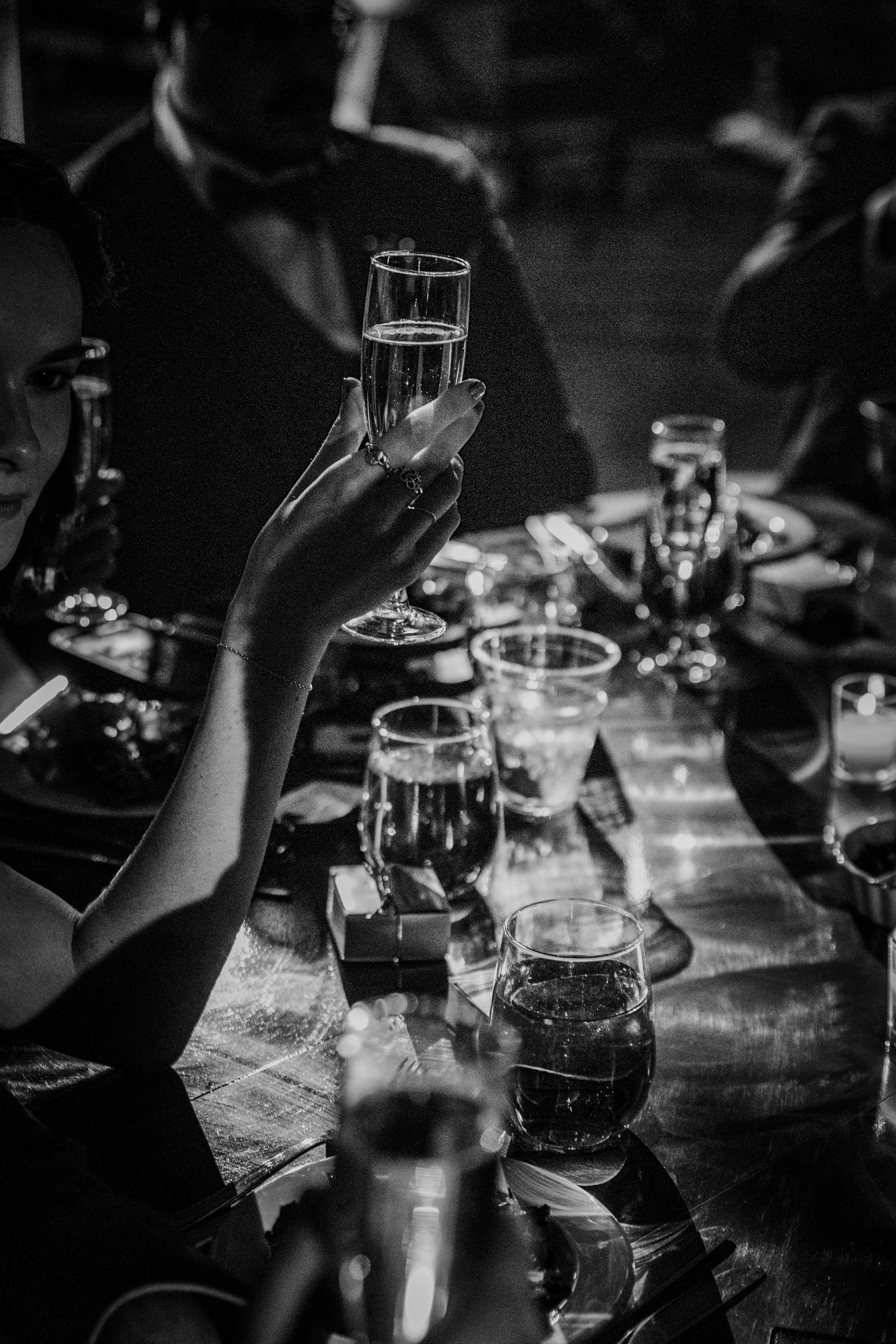 A champagne toast caught in dramatic light at the reception