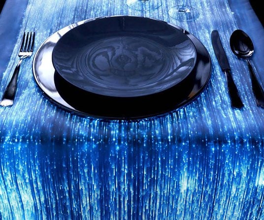 Glowing blue fiber optic table runner under a black place setting