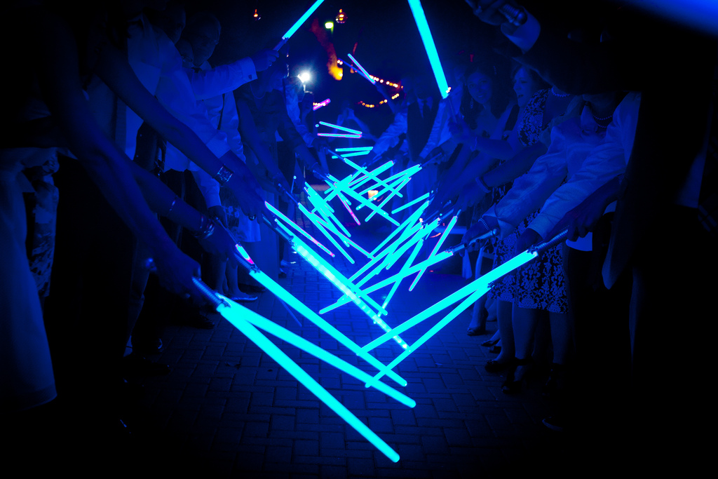 Guests form a glowing lightsaber tunnel for the couple’s night-time exit